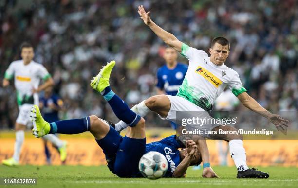 Bastian Oczipka of Schalke challenges Stefan Lainer of Mönchengladbach during the Bundesliga match between Borussia Mönchengladbach and FC Schalke 04...