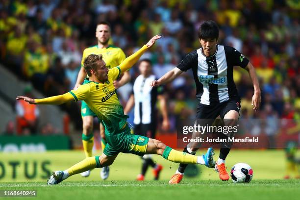 Ki Sung-Yueng of Newcastle is tackled by Tom Trybull of Norwich during the Premier League match between Norwich City and Newcastle United at Carrow...