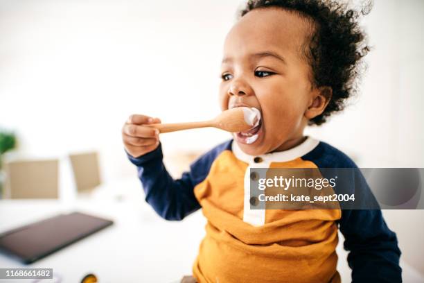 peuter yoghurt eten - baby eating yogurt stockfoto's en -beelden