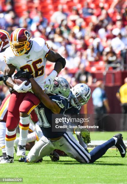 Washington Redskins running back Adrian Peterson runs the ball against Dallas Cowboys cornerback Byron Jones in the first quarter on September 15 at...