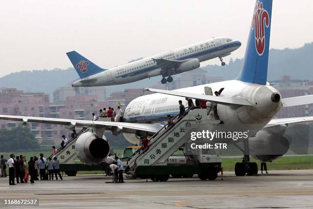 Passengers board the last of the China Southern airlines plane to take off from the old Baiyun airport in Guangzhou, southern China's Guangdong...