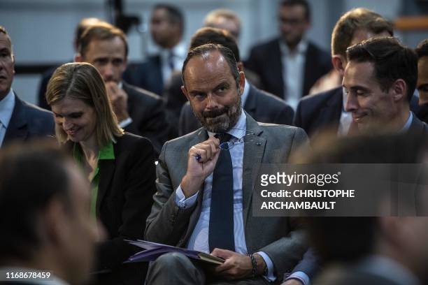French Prime Minister Edouard Philippe listens to talks during a visit to the ID Logistics platform in Aulnay-sous-Bois, northeast of Paris on...