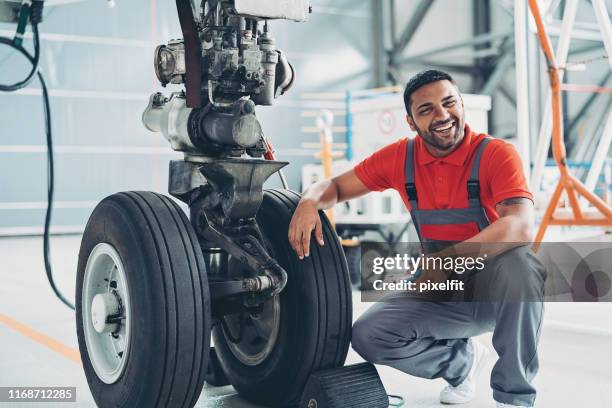 lächelnder mechaniker repariert ein flugzeug - landing gear stock-fotos und bilder