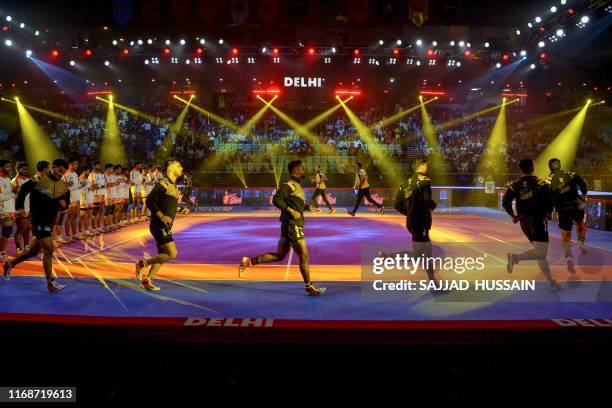 In this photograph taken on August 30 Telugu Titans players arrive on the court during the match between Telugu Titans and Puneri Paltan in the Pro...