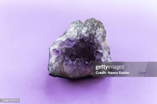 close up of amethyst crystal geode on a puple background - amethyst stock-fotos und bilder