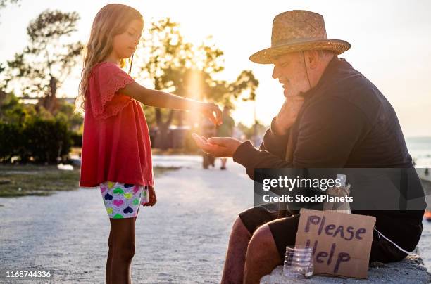 beauty girl giving money to homeless men - money donation stock pictures, royalty-free photos & images