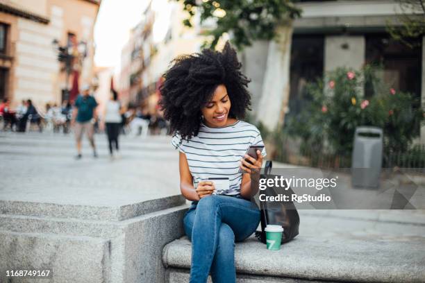 mooi meisje online winkelen op straat - internetbankieren stockfoto's en -beelden