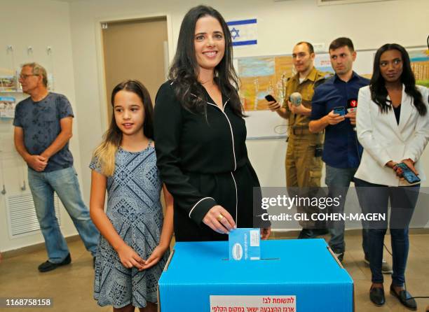 Israel's former justice minister Ayelet Shaked casts her ballot next to her daughter during Israel's parliamentary election at a polling station in...