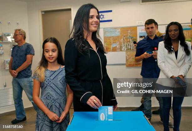 Israel's former justice minister Ayelet Shaked casts her ballot next to her daughter during Israel's parliamentary election at a polling station in...