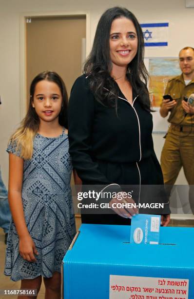 Israel's former justice minister Ayelet Shaked casts her ballot next to her daughter during Israel's parliamentary election at a polling station in...