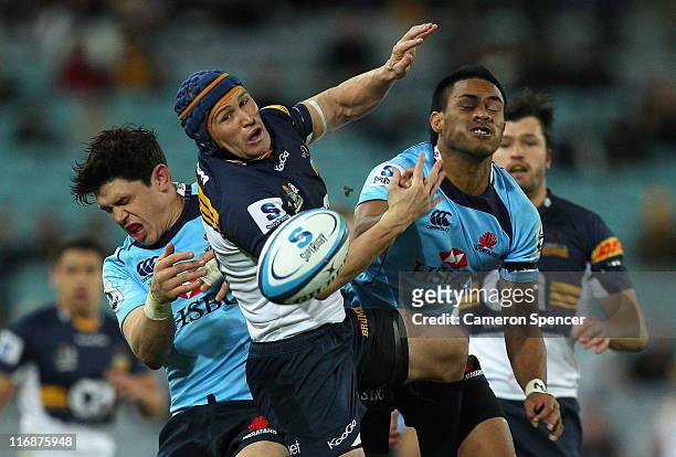 Matt Giteau of the Brumbies jumps for a high ball over Tom Carter and Atieli Pakalani of the Waratahs during the round 18 Super Rugby match between...