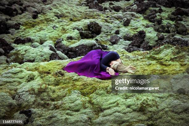 ethereal woman sleeping on mossy lavafield - woman curled up stock pictures, royalty-free photos & images