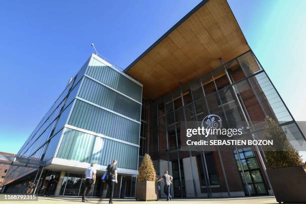 People pass by the US giant General Electric Belfort headquarters in Belfort, eastern France, on September 17, 2019. - About a hundred employees of...