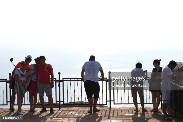 Tourists look out from the Alanya Castle on August 18, 2019 in Alanya, Turkey. Turkey’s resort towns saw a 100 percent occupancy rate with the Eid...