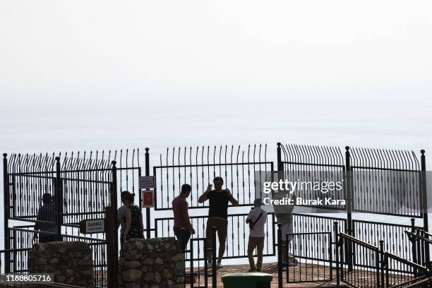 Tourists look out from the Alanya Castle on August 18, 2019 in Alanya, Turkey. Turkey’s resort towns saw a 100 percent occupancy rate with the Eid...