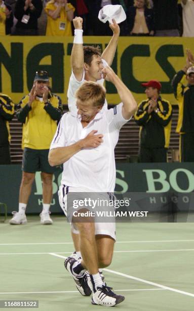 Australian doubles players Wayne Arthurs and Todd Woodbridge celebrate their five set victory over Switzerland in the doubles of their Davis Cup...