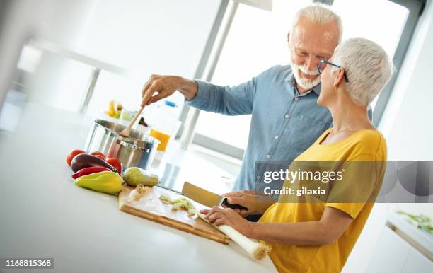 成熟したカップルが一緒に昼食を作る。 - middle aged couple cooking ストックフォトと画像