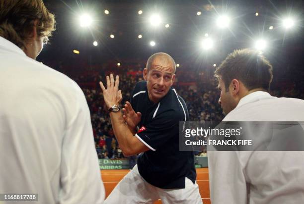French captain Guy Forget talks to Fabrice Santoro and his teammate Nicolas Escude during their Davis cup final double match against Russia's Marat...