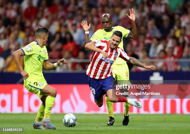 Vitolo of Atletico Madrid is tripped by Allan Nyom of Getafe during the Liga match between Club Atletico de Madrid and Getafe CF at Wanda...