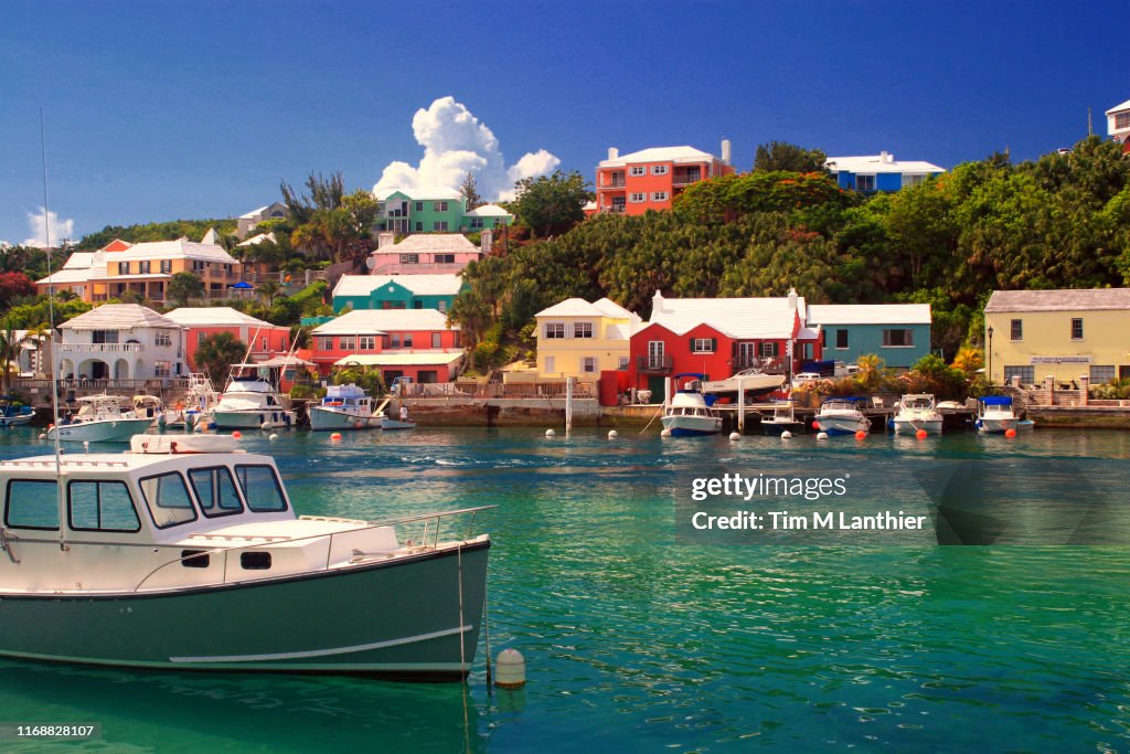 Boat in tropical water with colorful houses in background