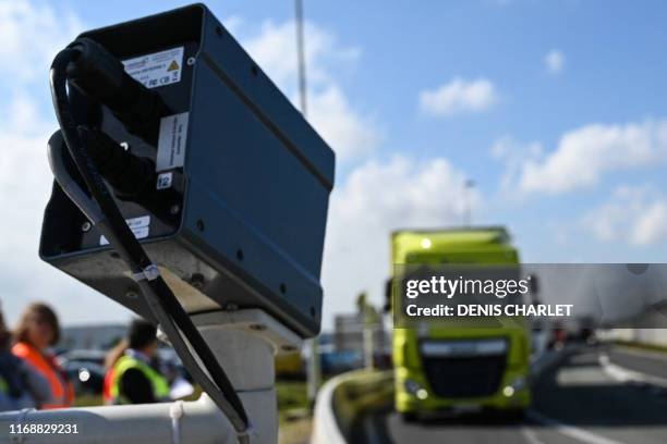 Truck driver waits as a camera checks his plate to determine if his loading will be checked by custom officers during a day of test in case of Brexit...