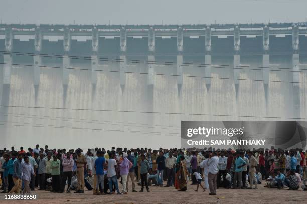 Visitors are pictured in front of Sardar Sarovar Narmada dam at Kevadia Colony of Narmada District, some 200 km from Ahmedabad, on September 17,...