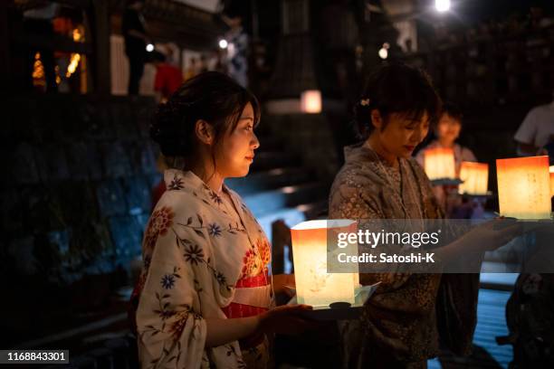 mother and daughter waiting in line at floating lantern festival - obon stock pictures, royalty-free photos & images
