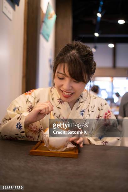 カフェでかきかき氷を食べる浴衣の若い女性 - かき氷 ストックフォトと画像