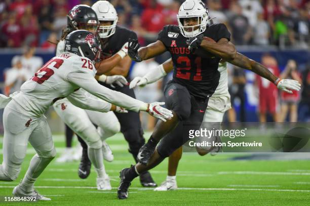 Houston Cougars running back Patrick Carr looks to bounce outside as Washington State Cougars safety Bryce Beekman defends during the Advocare...