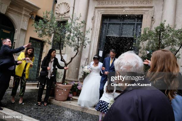 Rice seeds are thrown over a just married couple while they walk out of a church in the back streets of Campo dei Fiori market on May 18, 2019 in...