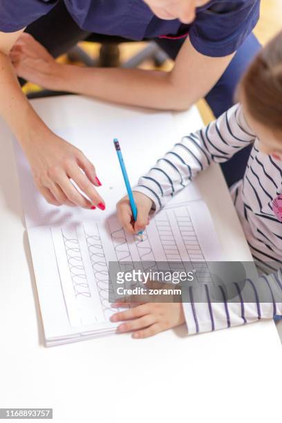 girl tracing in exercise book with pencil - workbook stock pictures, royalty-free photos & images
