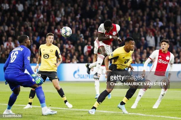 Ajax's Dutch forward Quincy Promes heads the ball and scores past Lille's French goalkeeper Mike Maignan during the UEFA Champions league Group H...