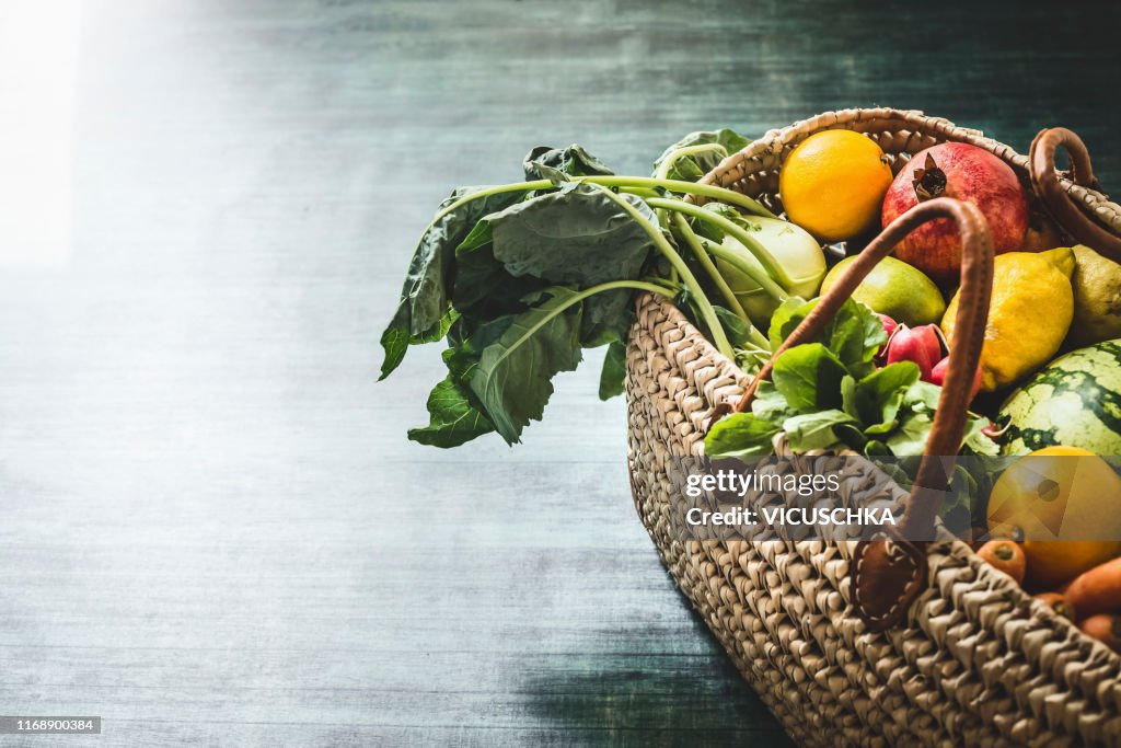 Wicker basket with various organic vegetables and fruits from market
