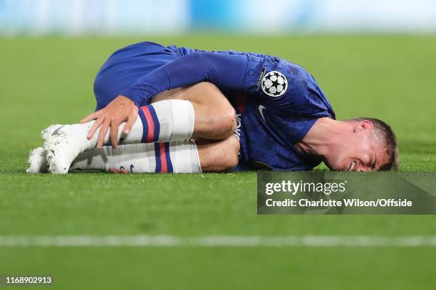 Mason Mount of Chelsea grimaces in pain as he clutches his injured ankle during the UEFA Champions League group H match between Chelsea FC and...