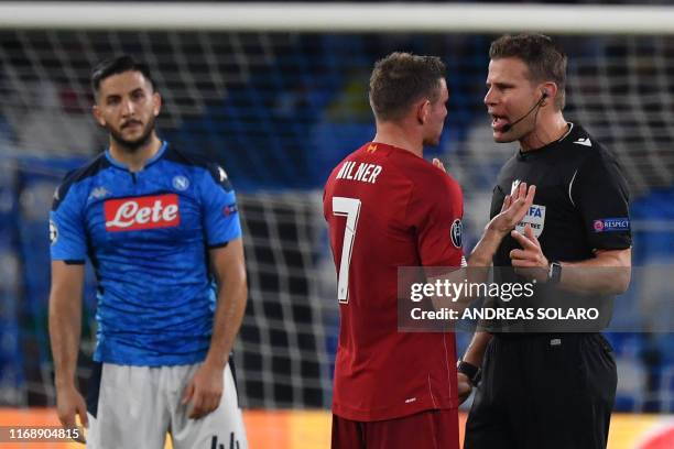 Liverpool's English midfielder James Milner argues with German referee Felix Brych as Napoli's Greek defender Konstantinos Manolas looks on during...