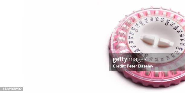 hrt pills in pink calendar dispenser pill box - hrt pill stockfoto's en -beelden