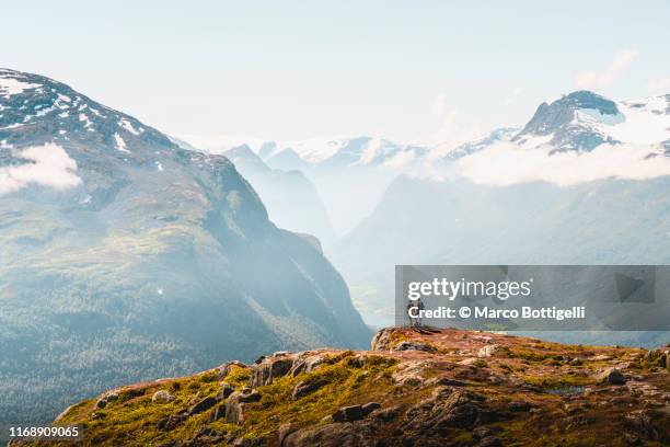 tourists admiring the view from the top of a mountain in loen, norway - paisaje espectacular fotografías e imágenes de stock