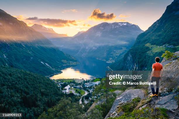 man admiring geiranger and the geirangerfjord at sunset, norway - geiranger stock pictures, royalty-free photos & images