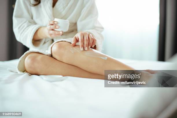 femme, soins de la peau, crème, chambre. femme prenant soin de ses jambes à la maison - body photos et images de collection