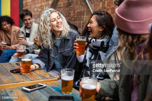 londoners groep vrienden ontmoeten elkaar in een pub - london england stockfoto's en -beelden