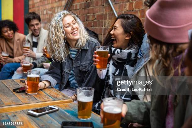 londoners group of friends meet up in a pub - friends drinking stock pictures, royalty-free photos & images