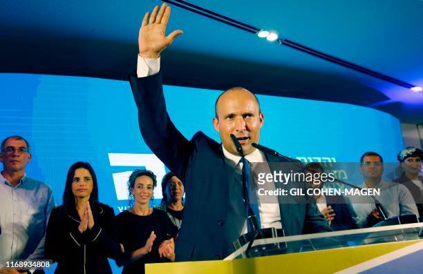 Naftali Bennett , member and candidate for the New Right party that is part of the Yamina political alliance, speaks while flanked by party leader...