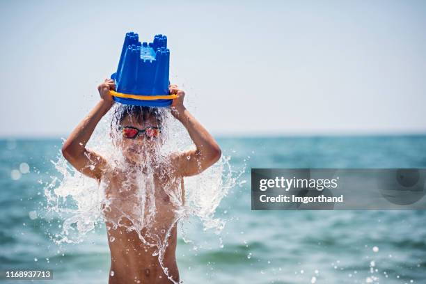 little boy cooling himself with bucket of water - balde imagens e fotografias de stock