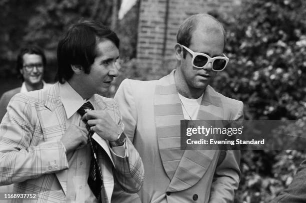English singer, songwriter, pianist, and composer Elton John and his manager John Reid on their way to a luncheon in honour of Buddy Holly at the...