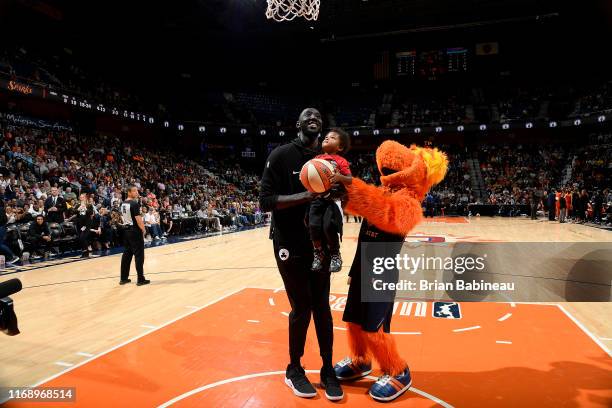 Tacko Fall of the Boston Celtics helps a baby shoot the ball during the halftime between Los Angeles Sparks and the Connecticut Sun on September 17,...