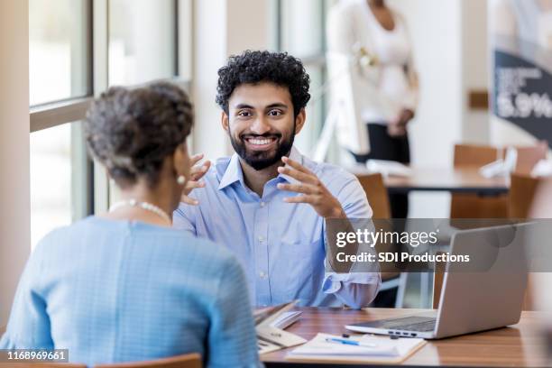 male bank employee discusses bank services with customer - credit union stock pictures, royalty-free photos & images