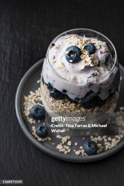 blueberries, oat flakes and curd cheese in a glass on dark background. - schist fotografías e imágenes de stock