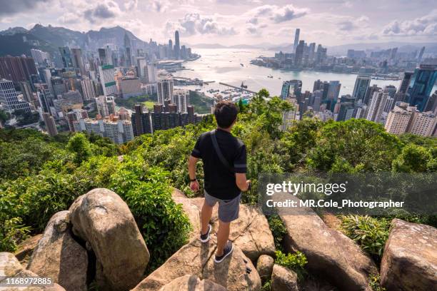 asian man traveler is visiting at braemar hill peak,tourist looking to hong kong city view and victoria harbor - tropical climate fotografías e imágenes de stock