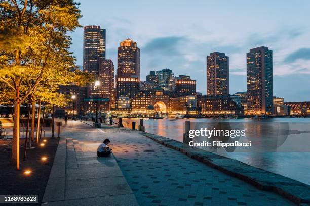 surfen op het net op smart phone in boston - boston seaport stockfoto's en -beelden