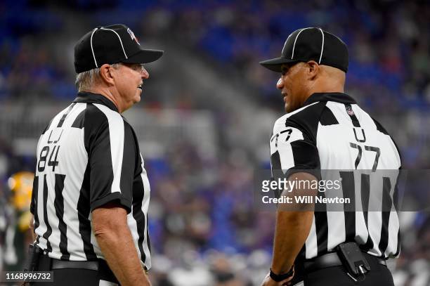 Line judge Mark Steinkerchner and referee Terry McAulay speak during the second half of a preseason game between the Baltimore Ravens and the Green...